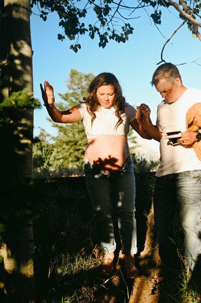 Pregnant mama walking down a hill with husband during her driggs maternity session