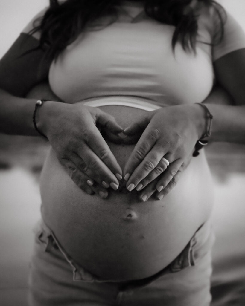 Pregnant mama with her hands making a heart on her belly during her Driggs Maternity Session