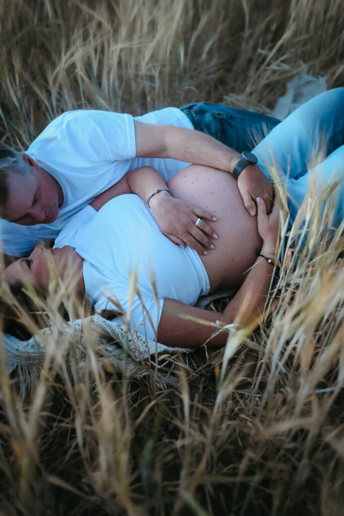 Pregnant mama laying in a field during her Driggs Maternity Session