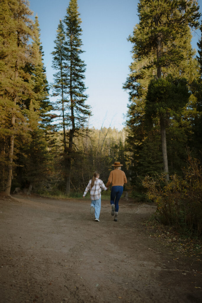 Mother and daughter walking through the forest during a family session by Teton Valley Idaho Newborn Photographer