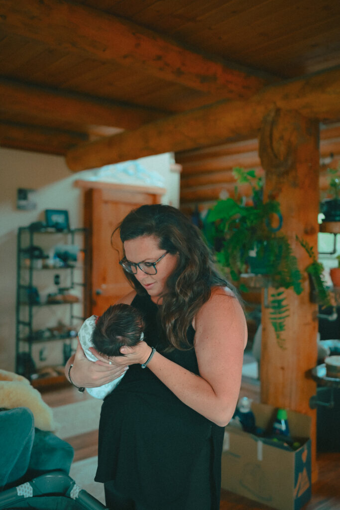 New mom holding newborn baby in teton valley newborn photo session