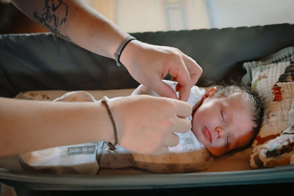 Mom getting ready to pick up baby during newborn photography session