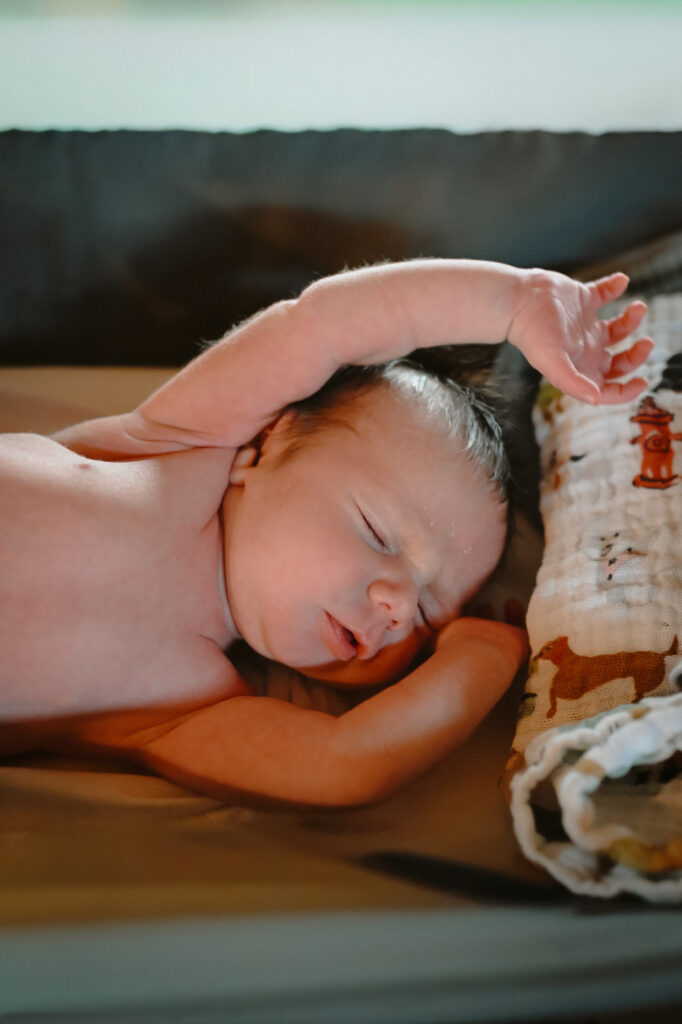 Newborn baby sleeping with arms up during newborn photo session