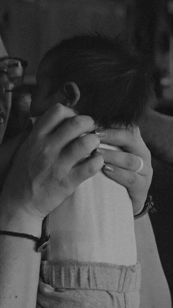 Mother holding up baby to face her during newborn photography session