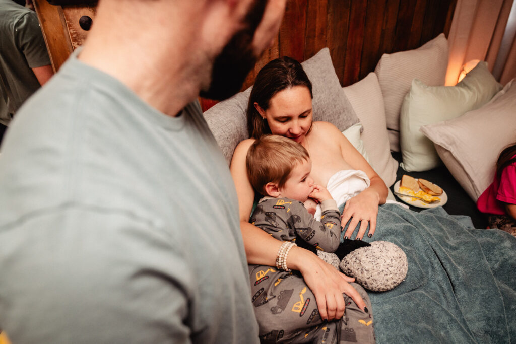 Big brother with mama in bed following home birth of baby sister