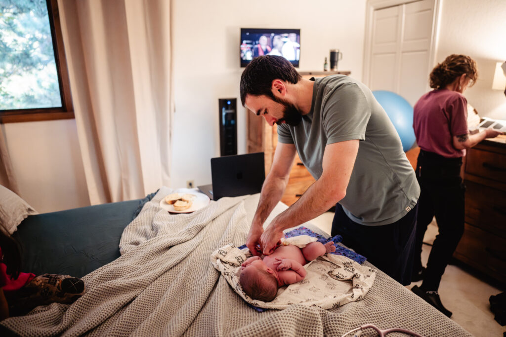 Dad helping with newborn exam after home birth