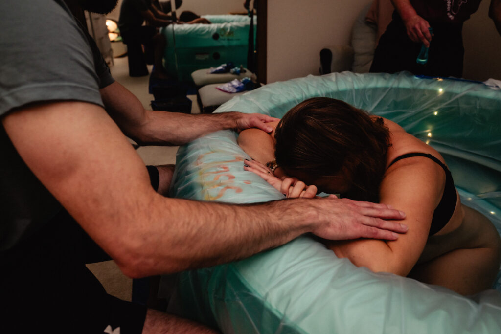 Mother in transition laboring in birth pool