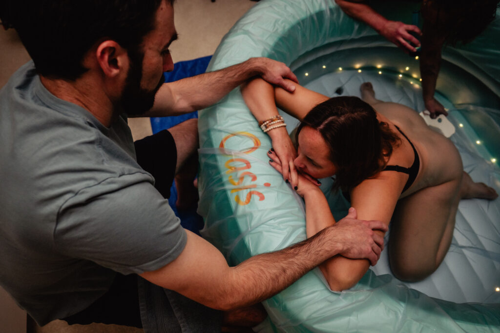 Laboring in birth pool just prior to birth captured by birth photographer