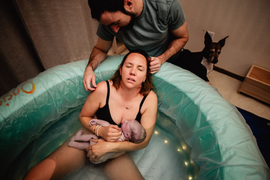 New mom, dad and baby just after home birth in pool