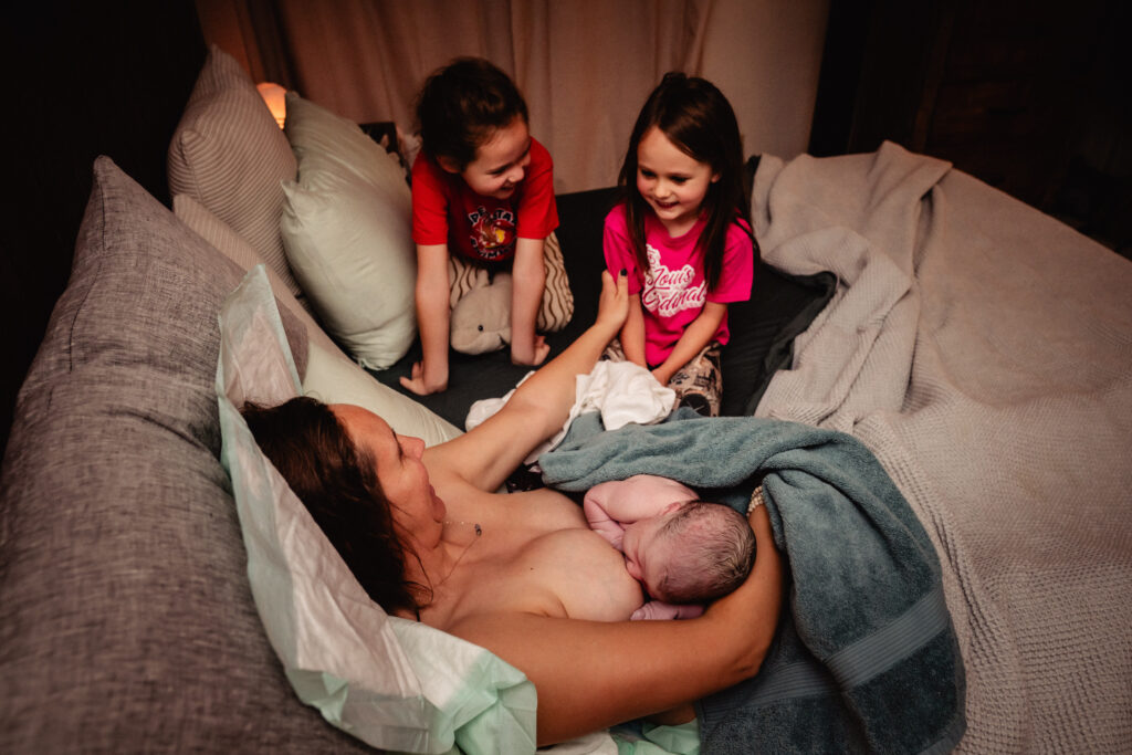 Sisters meeting newborn sibling for the first time
